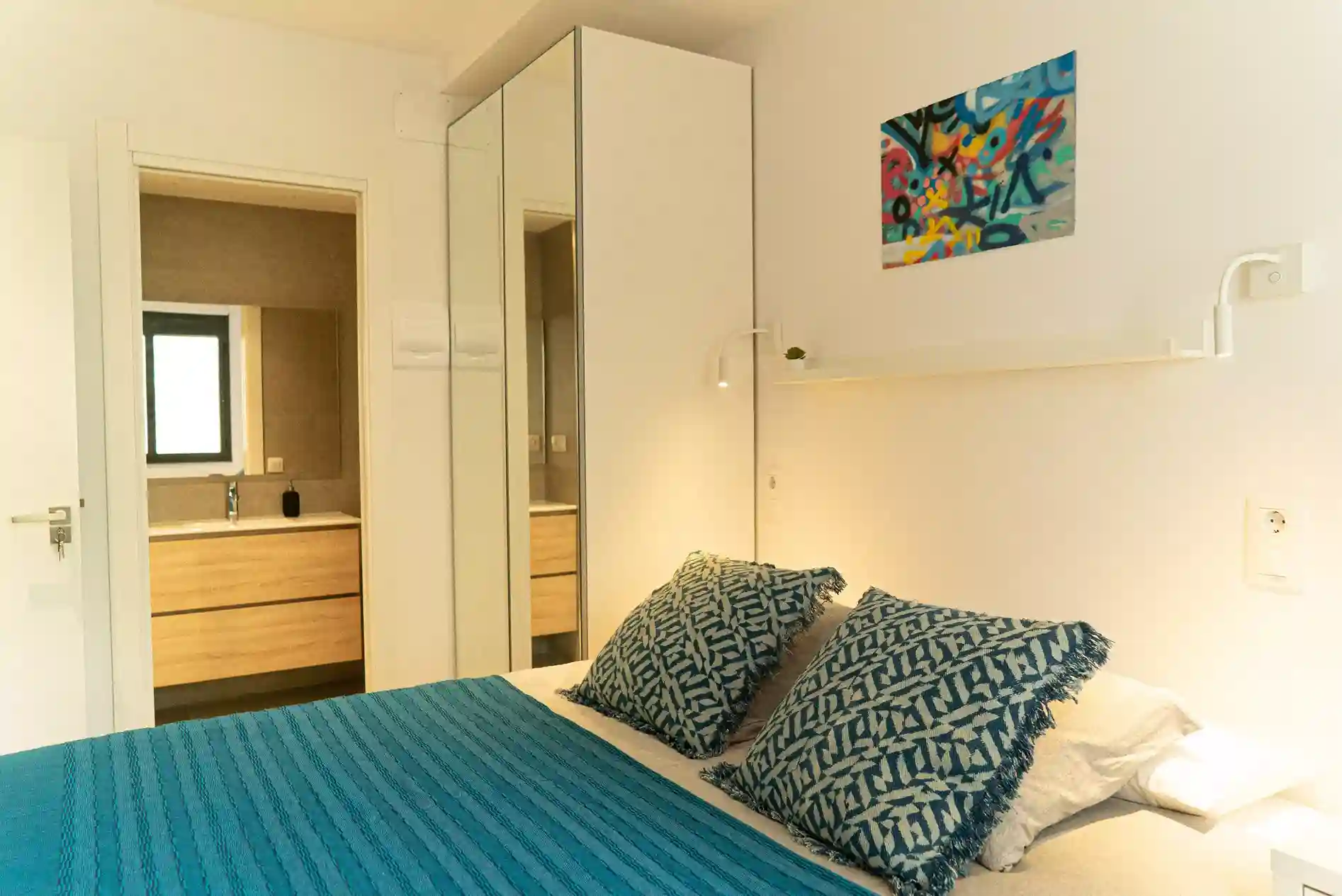Habitación en Coliving Vibes Collblanc con cama doble, armario con espejo y baño privado en suite