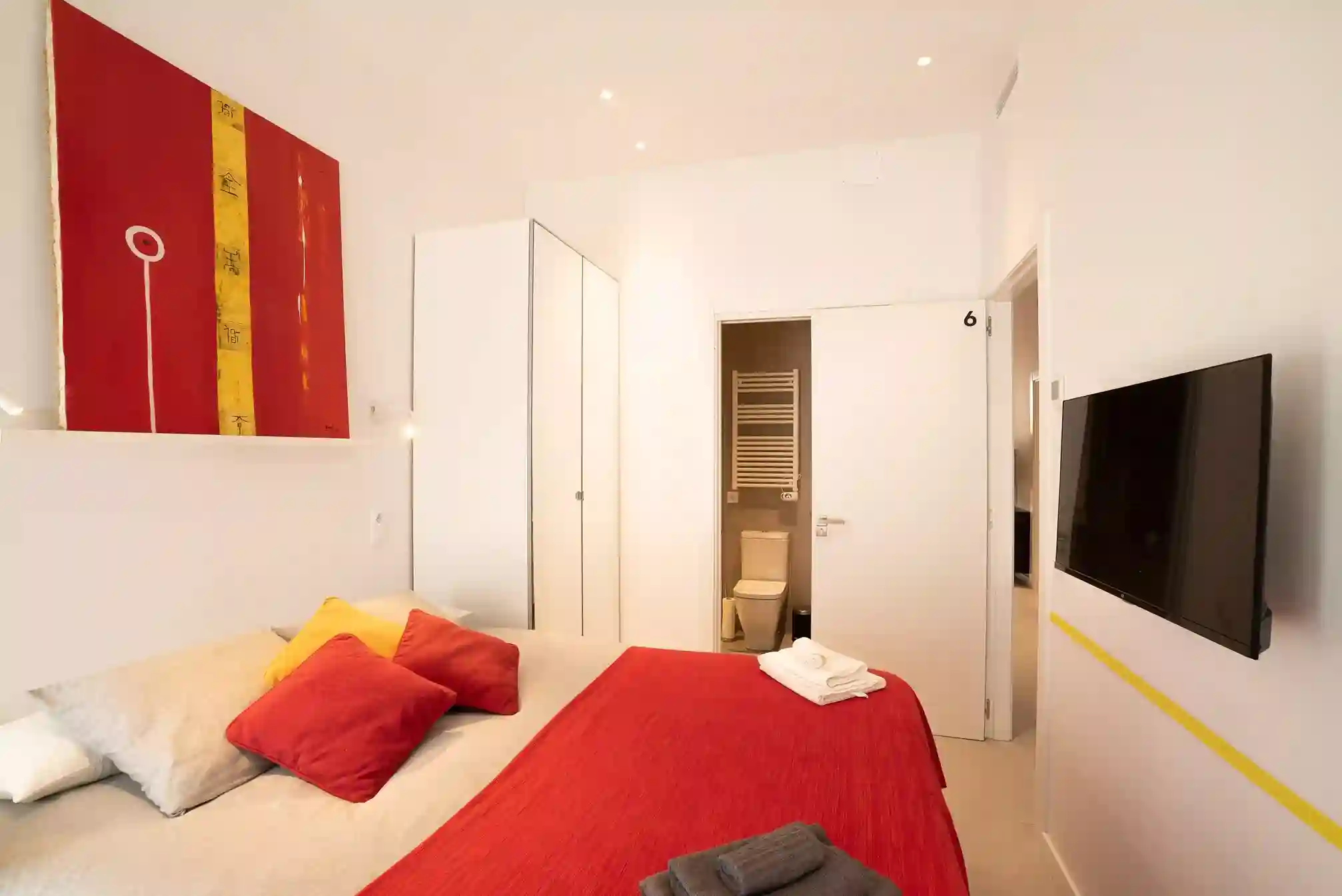 Habitación Pedrera en Coliving Vibes Collblanc con cama doble, baño en suite, Smart TV y decoración moderna en tonos rojos